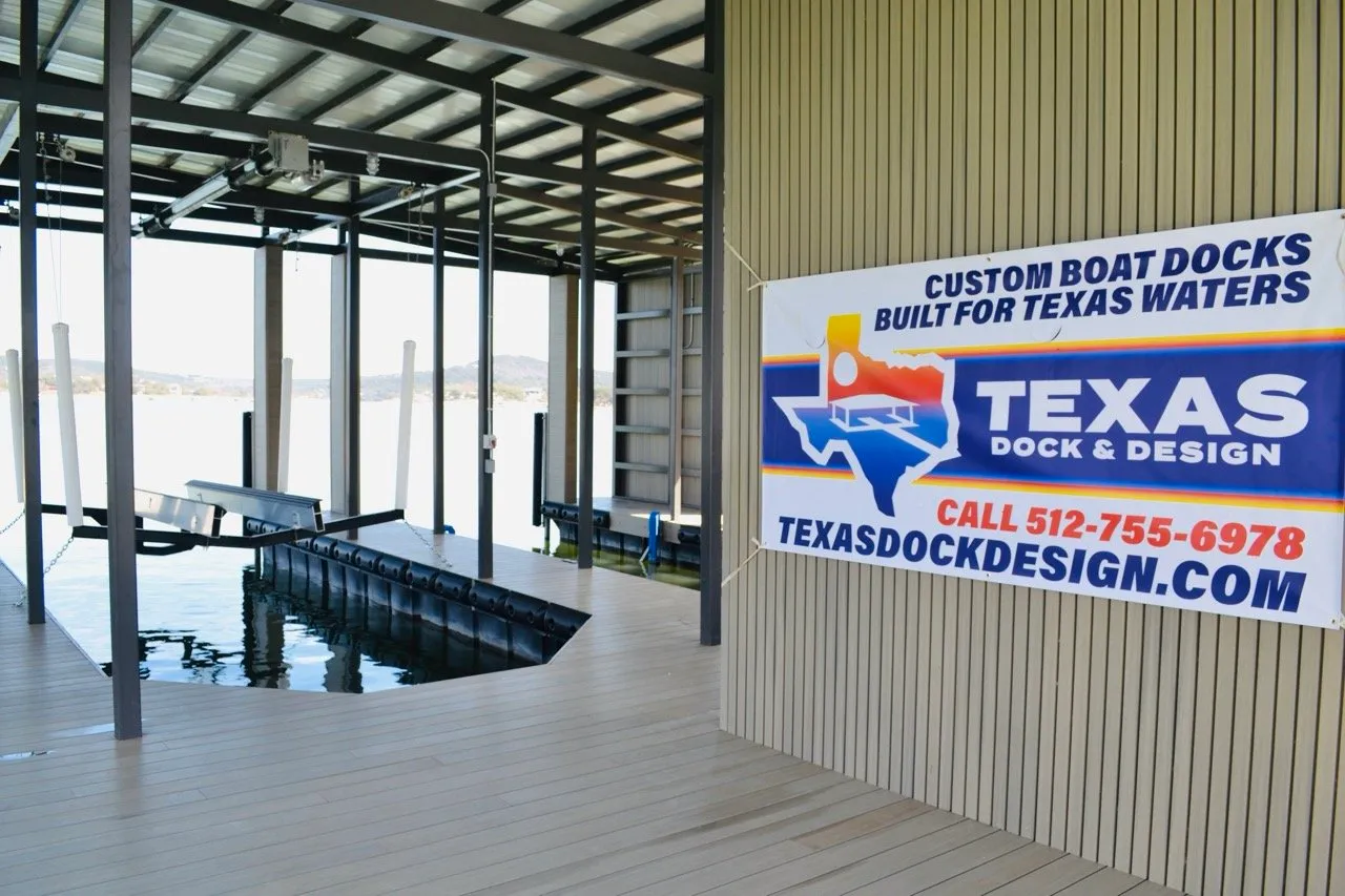 Texas Dock & Design banner reading Custom Boat Docks Built for Texas Waters, hanging inside a finished covered boathouse