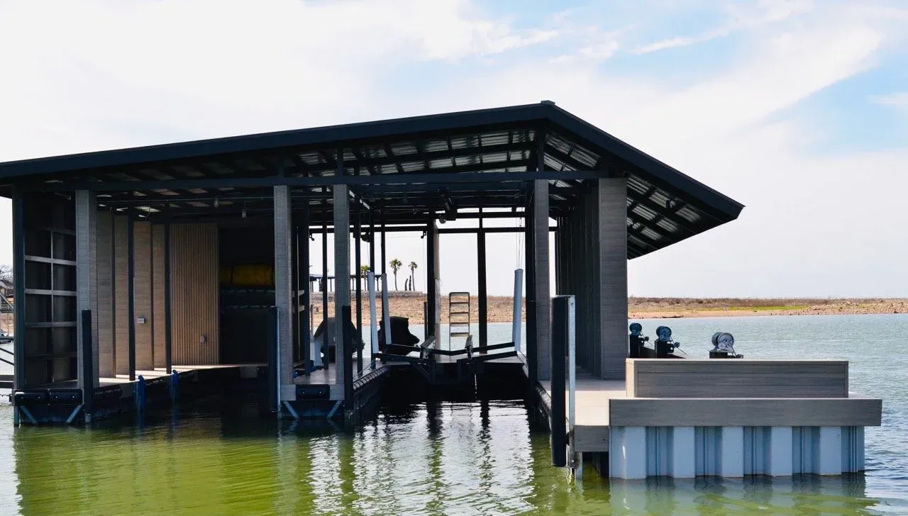 Modern steel boathouse with an open-beam roof, boat lift and two PWC lifts